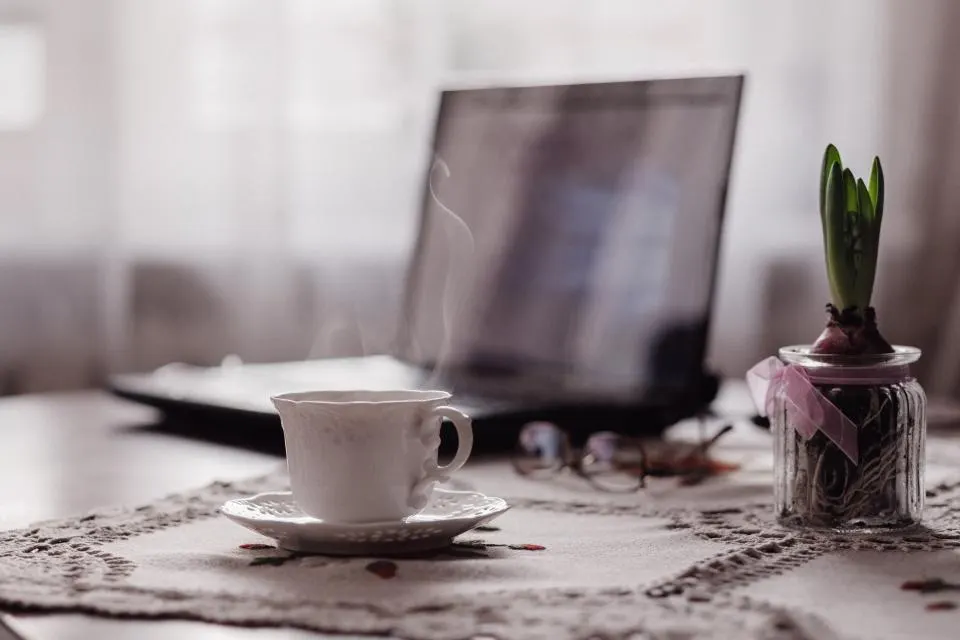Laptop and coffee on a desk, representing working with a web designer
