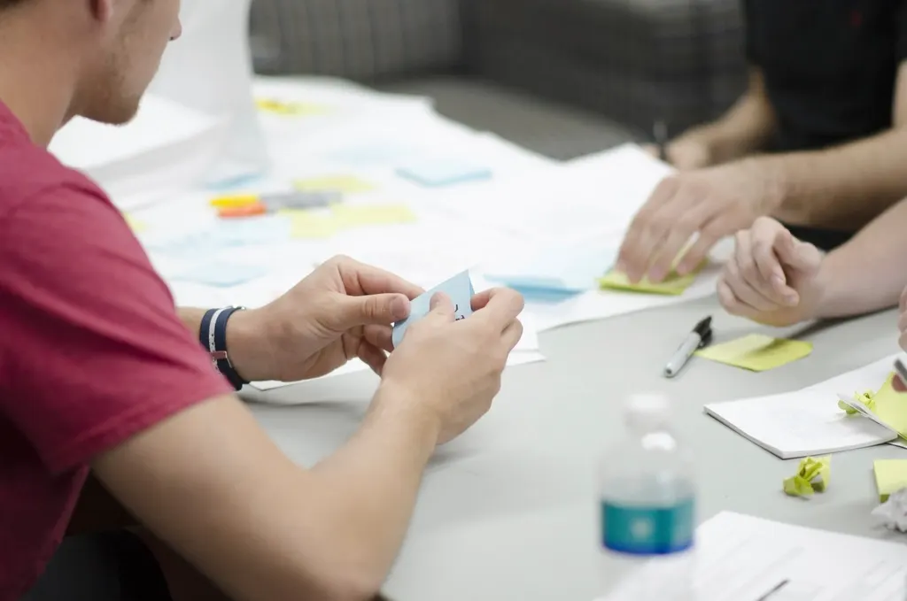 People working together around a table with notes, like a tutoring session